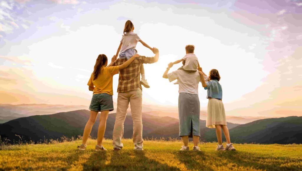 Eine Familie schaut sich den Sonnenaufgang an.