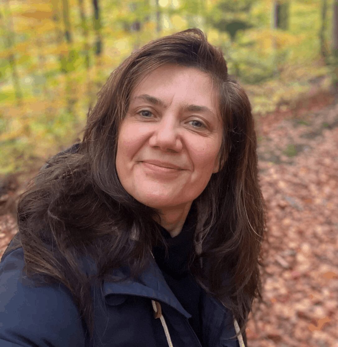 Kräuterfrauen-Business Community 1 Yvy im Wald in die Kamera lächelnd